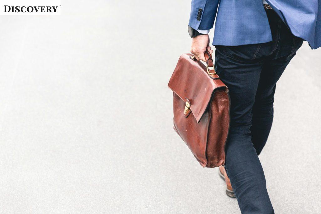 person walking holding brown leather bag